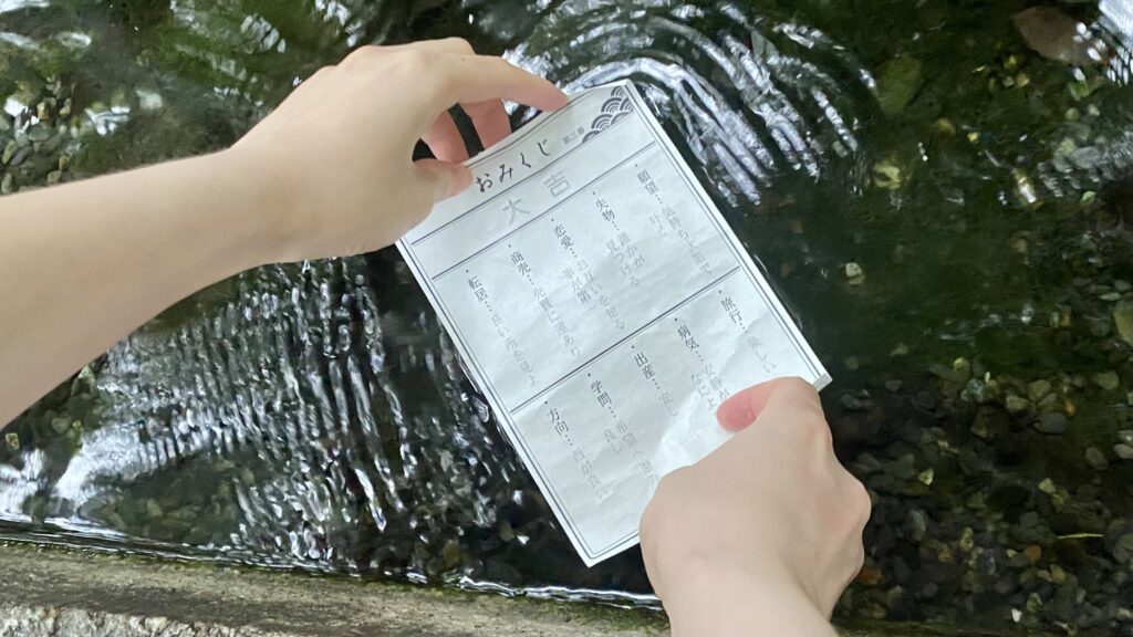 小川におみくじをひたす様子